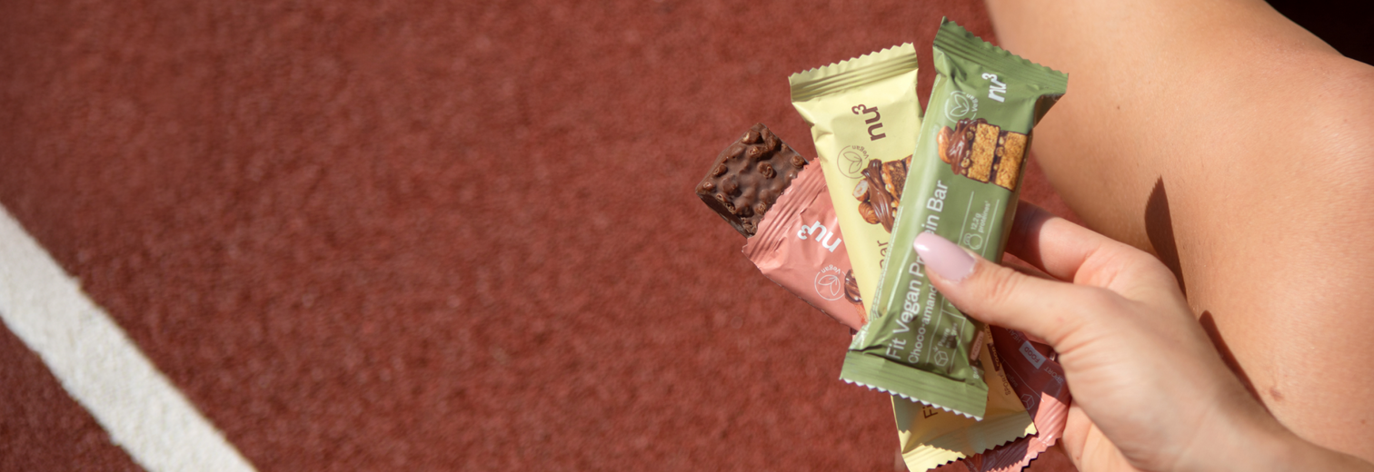 Frauenhand hält Proteinriegel