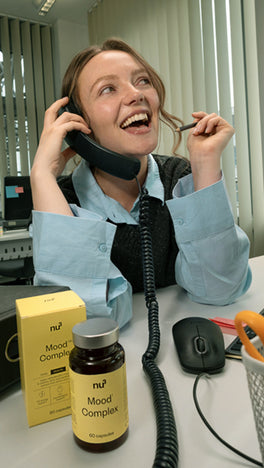 Frau im Büro telefoniert neben ihr Mood Complex Kapseln