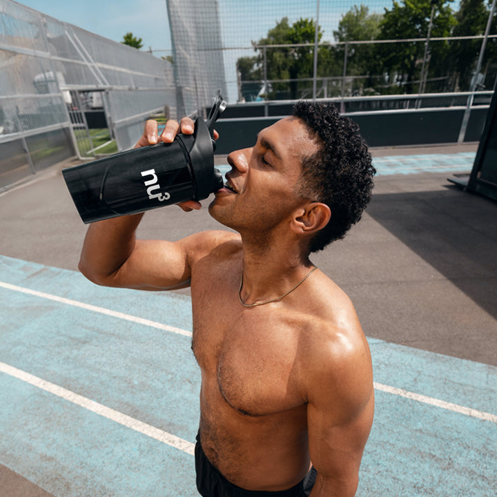 Sportlicher Man trinkt aus nu3 Shaker