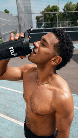 Sportlicher Man trinkt aus nu3 Shaker