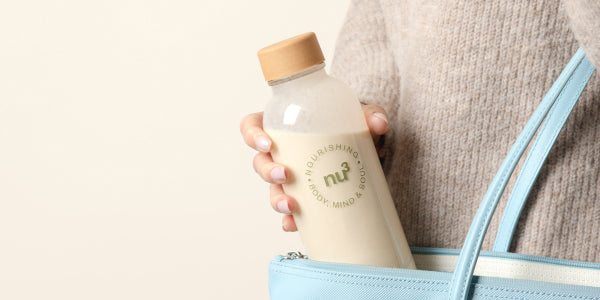 Frau packt Wasserflasche in Handtasche