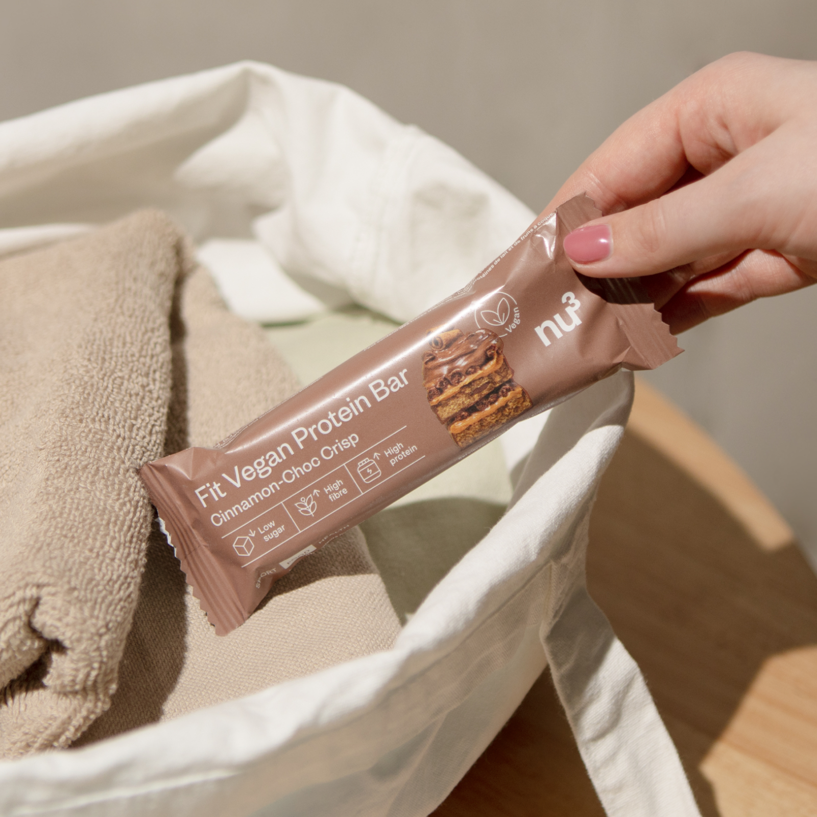 Hand packt veganen Proteinriegel in eine Sporttasche