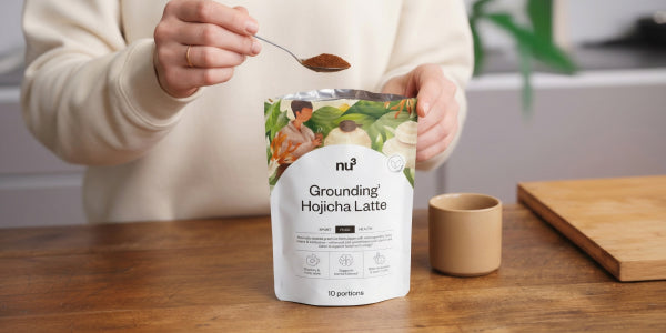 Pouch mit Hojicha Instant-Latte, einem Löffel mit Pulver und einer Tasse